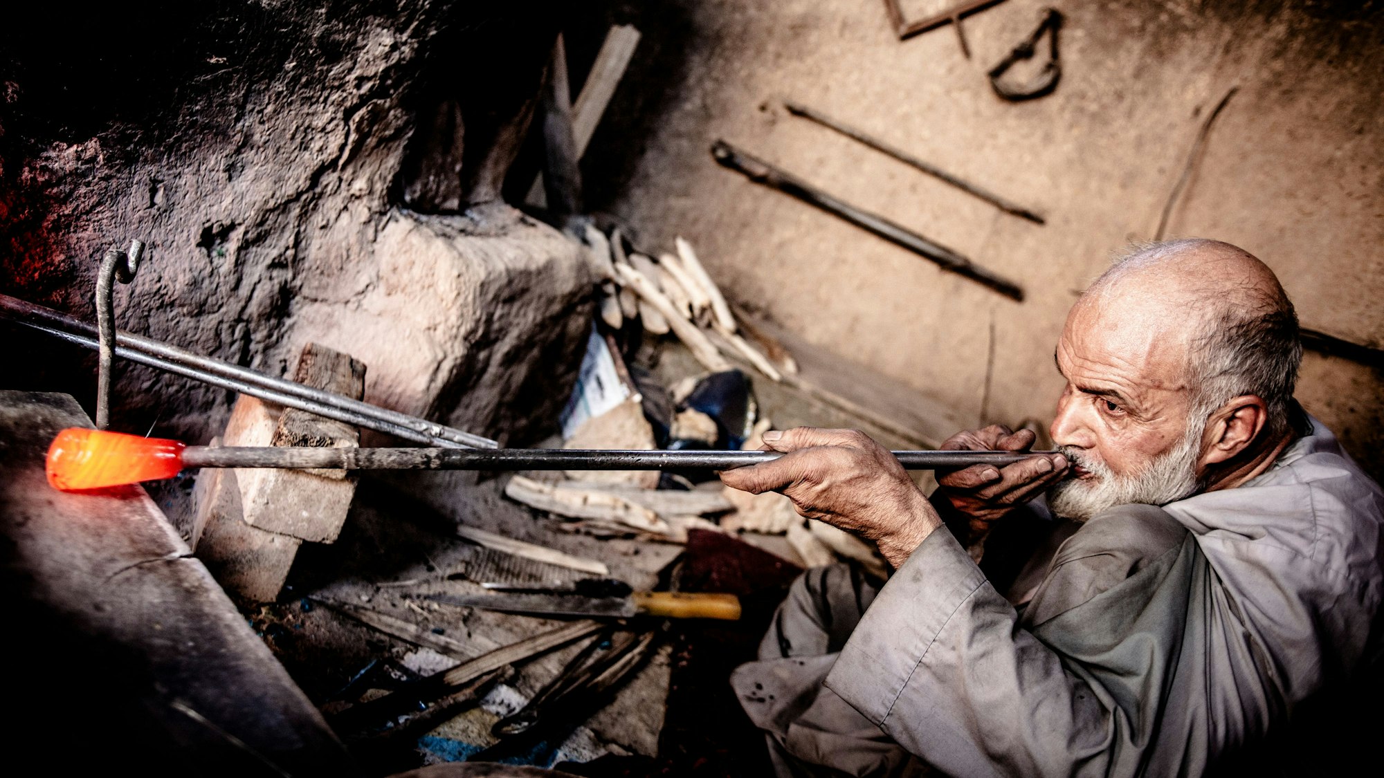 Nasrullah Faisi beim Glasblasen in seiner Werkstatt in Herat.