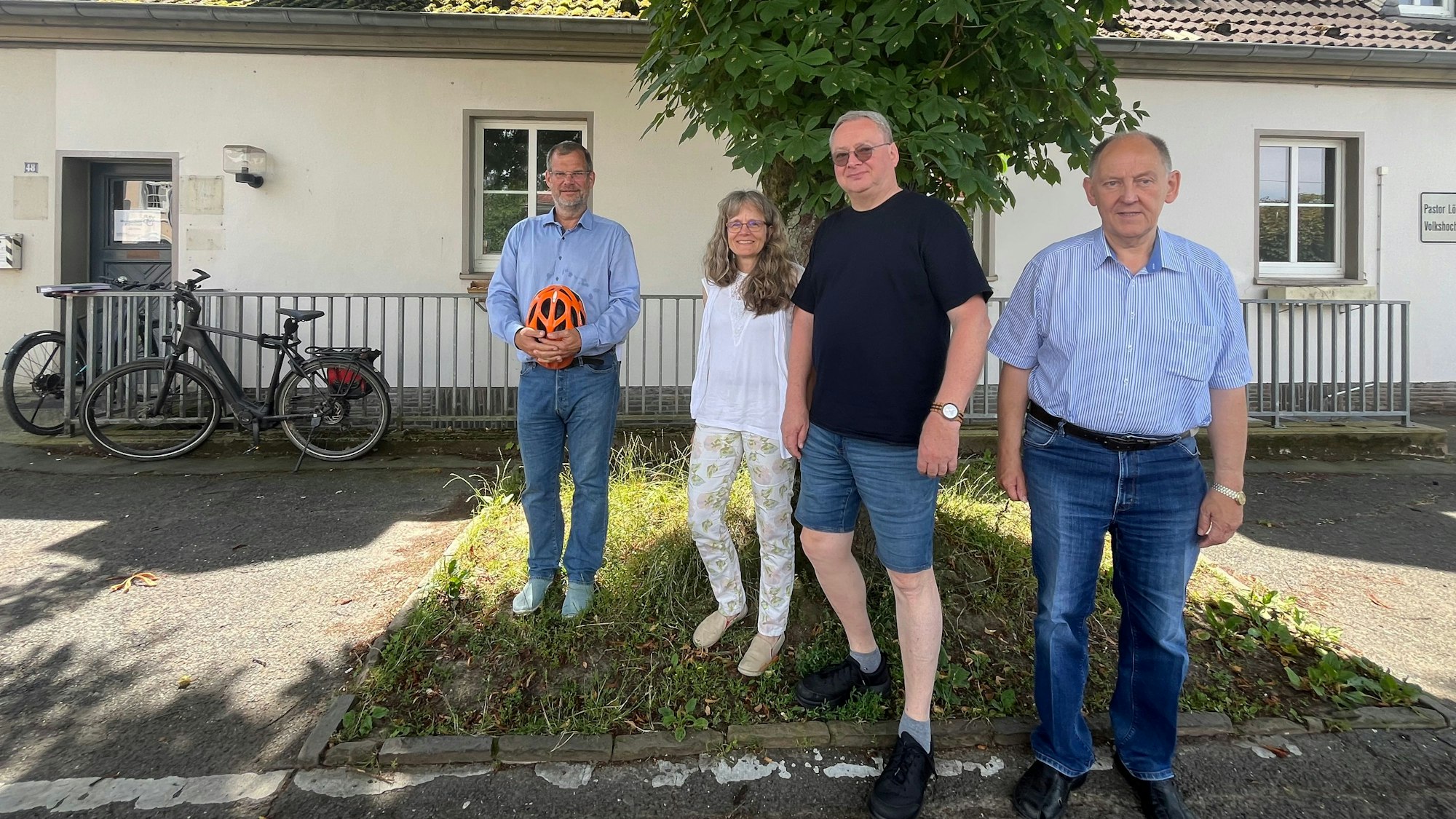 Vier Menschen vor einem Gebäude