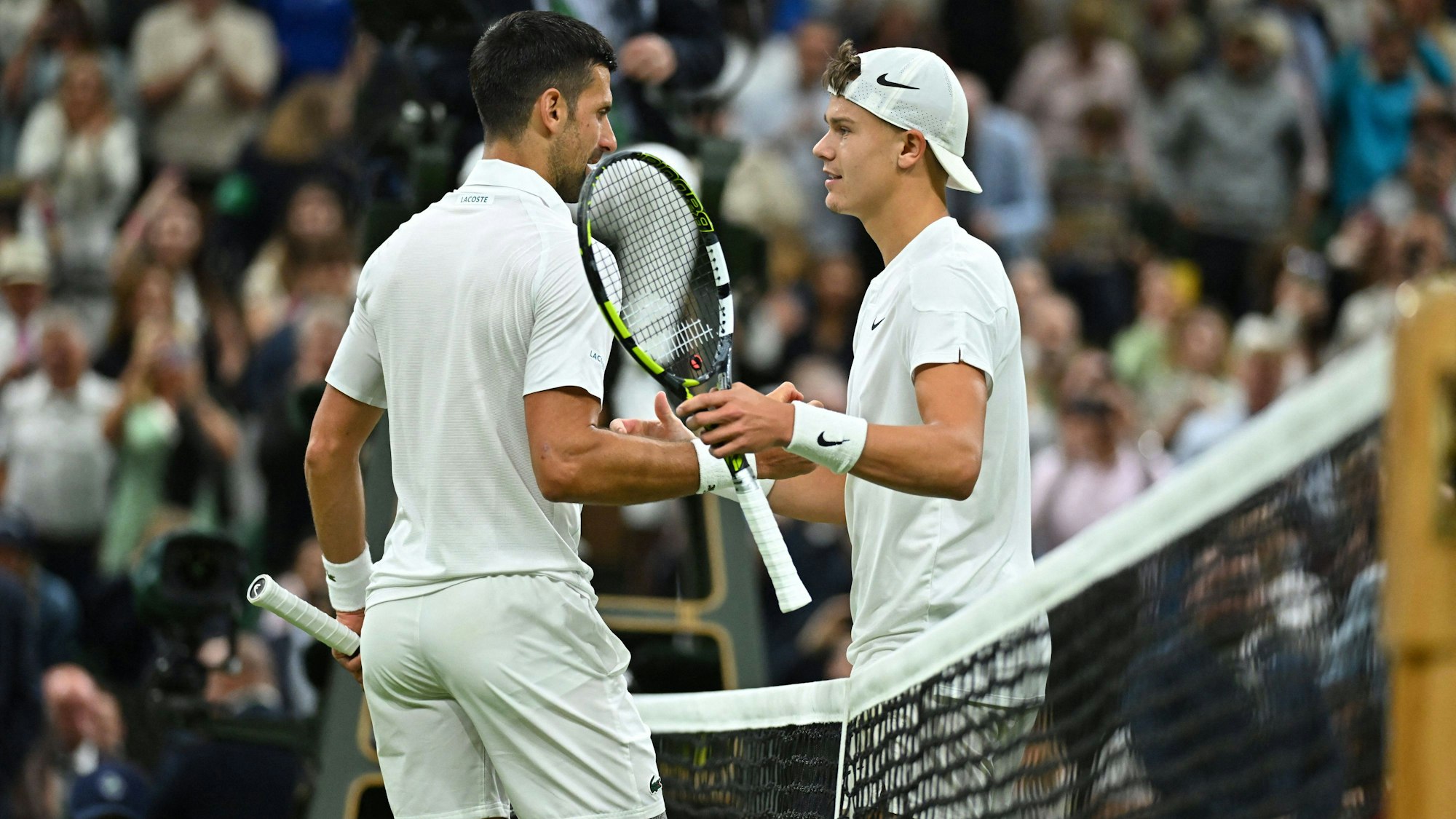 Novak Djokovic und Holger Rune geben sich nach dem Match die Hand.