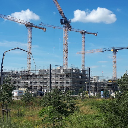 Die Baustelle des neuen „Simonsveedel“ in Weidenpesch. Fünf Baukräne ragen über die im Bau befindlichen Gebäude.