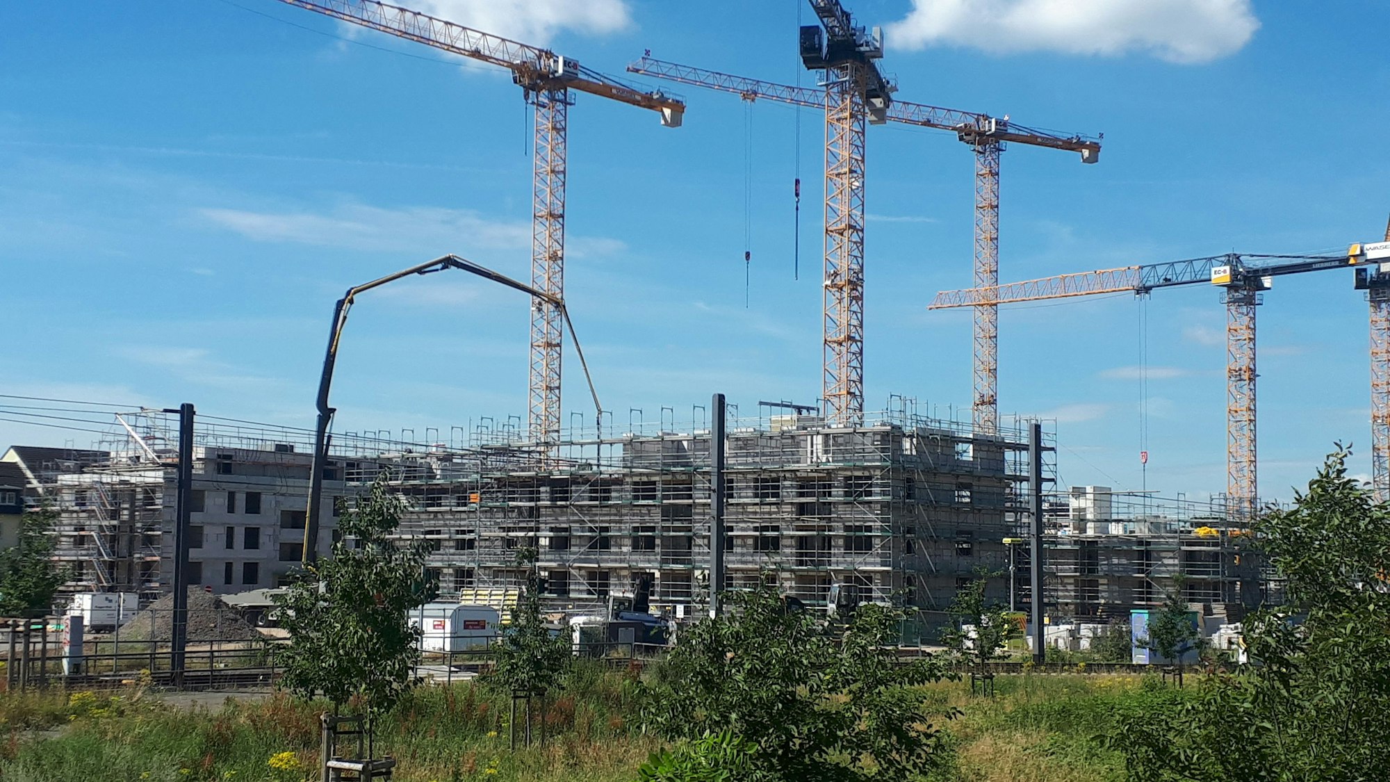Die Baustelle des neuen „Simonsveedel“ in Weidenpesch. Fünf Baukräne ragen über die im Bau befindlichen Gebäude.