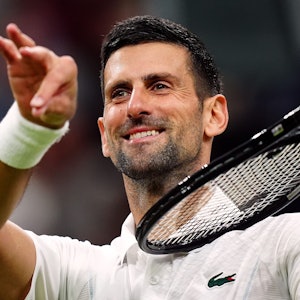 Novak Djokovic tut so, als würde er Geige spielen, nachdem er den Dänen Rune geschlagen hat.