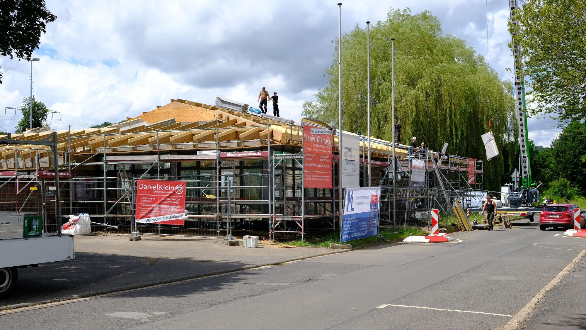 Bauhandwerker sind mit der Sanierung der Dachkonstruktion der Bürgerhalle in Kall beschäftigt.