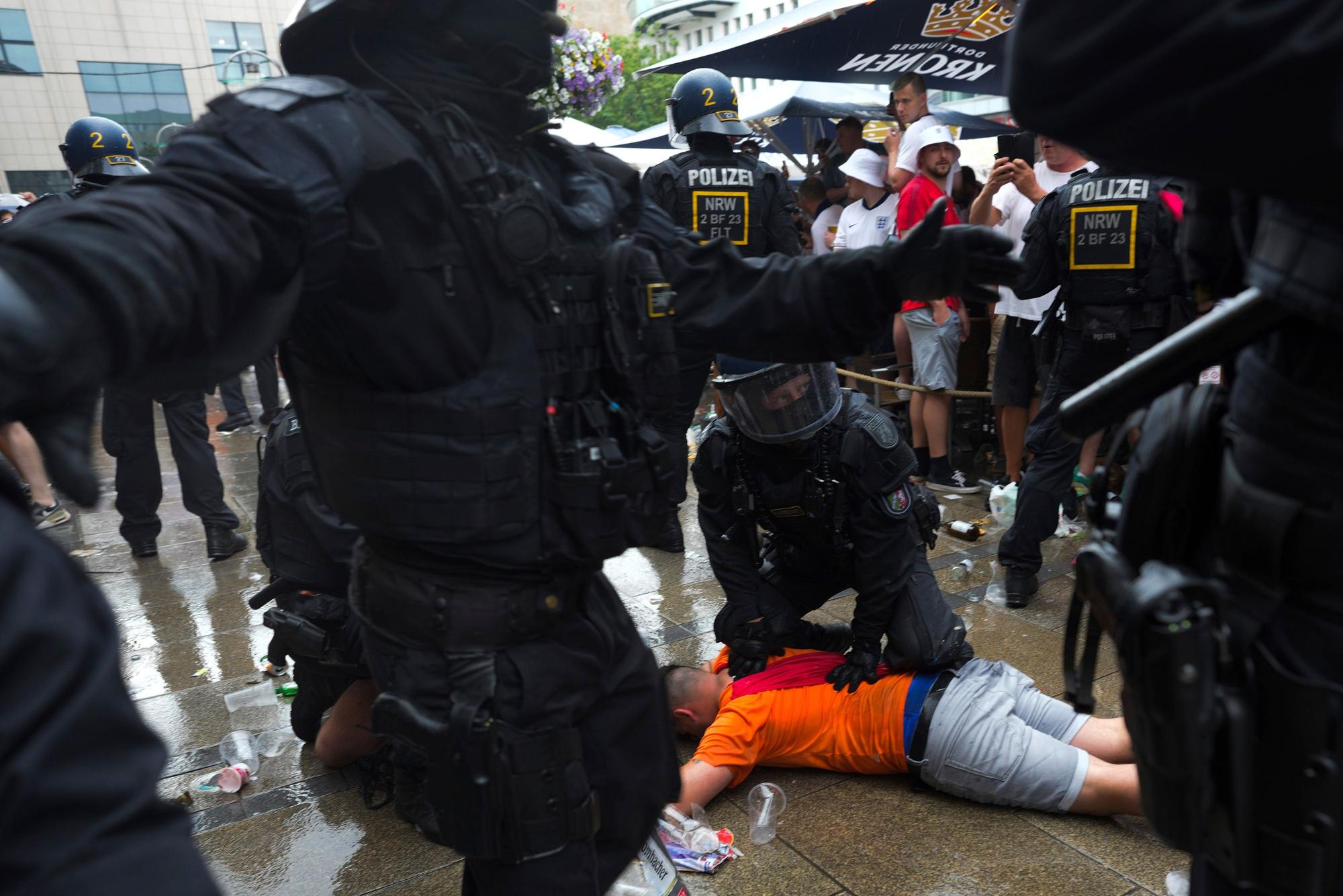 10.07.2024, Nordrhein-Westfalen, Dortmund: Fußball, UEFA Euro 2024, EM, Niederlande - England, Finalrunde, Halbfinale, Polizeibeamte halten einen Fußballfan vor dem Halbfinalspiel zwischen den Niederlanden und England bei der Fußball-Europameisterschaft fest. Foto: Markus Schreiber/AP/dpa +++ dpa-Bildfunk +++