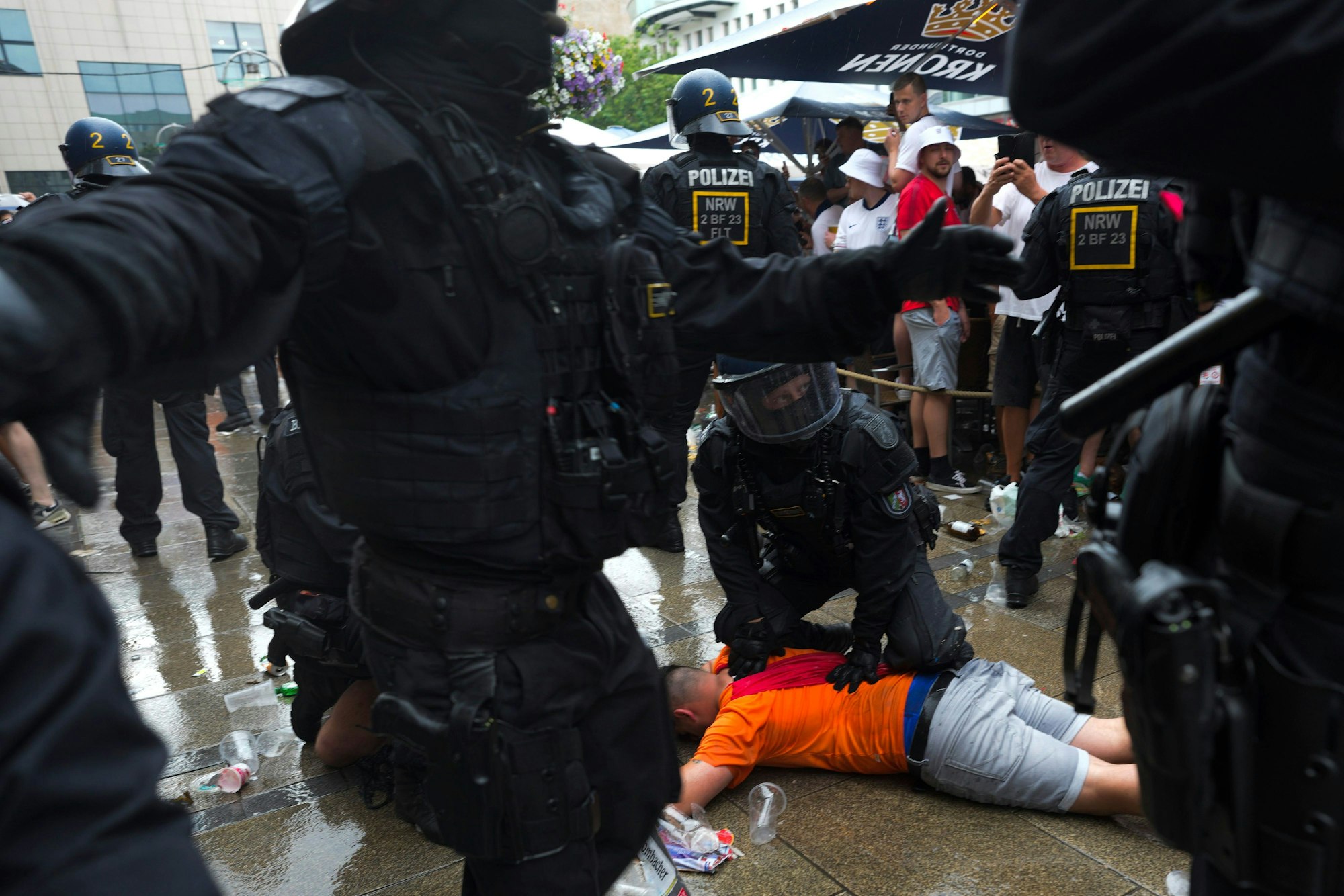 10.07.2024, Nordrhein-Westfalen, Dortmund: Fußball, UEFA Euro 2024, EM, Niederlande - England, Finalrunde, Halbfinale, Polizeibeamte halten einen Fußballfan vor dem Halbfinalspiel zwischen den Niederlanden und England bei der Fußball-Europameisterschaft fest. Foto: Markus Schreiber/AP/dpa +++ dpa-Bildfunk +++