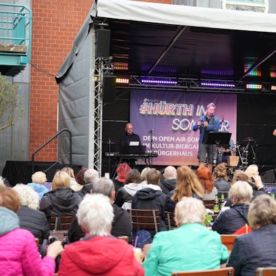 Eine Band steht auf der Freilichtbühne am Hürther Bürgerhaus.