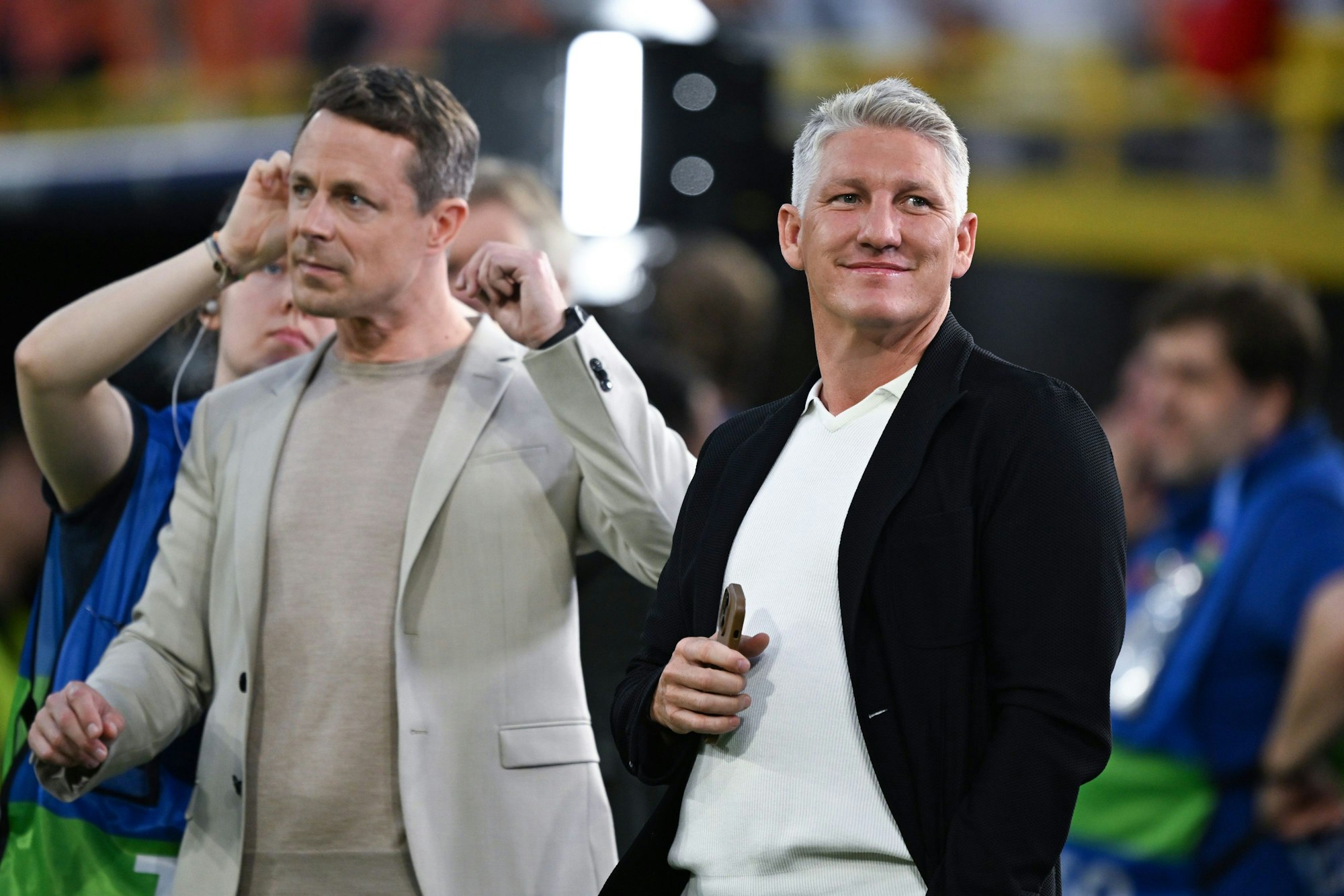 10.07.2024, Nordrhein-Westfalen, Dortmund: Fußball, UEFA Euro 2024, EM, Niederlande - England, Finalrunde, Halbfinale, Stadion Dortmund, der ehemalige Fußball-Weltmeister Bastian Schweinsteiger (r) steht als TV-Experte neben Moderator Alexander Bommes in der Arena. Foto: Bernd Thissen/dpa +++ dpa-Bildfunk +++