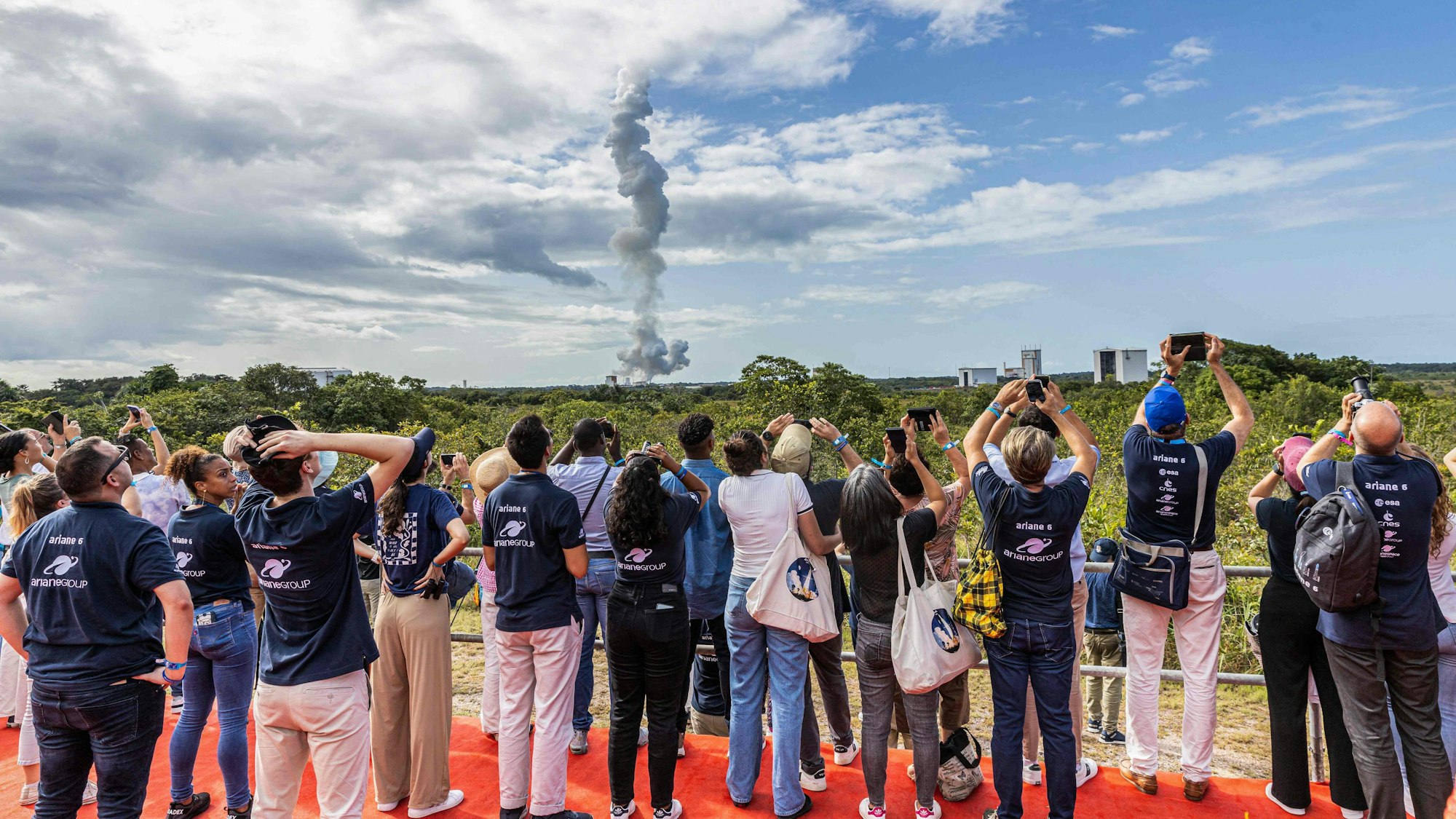 Aus sicherer Entfernung beobachten einige Menschen den Start von Ariane 6.