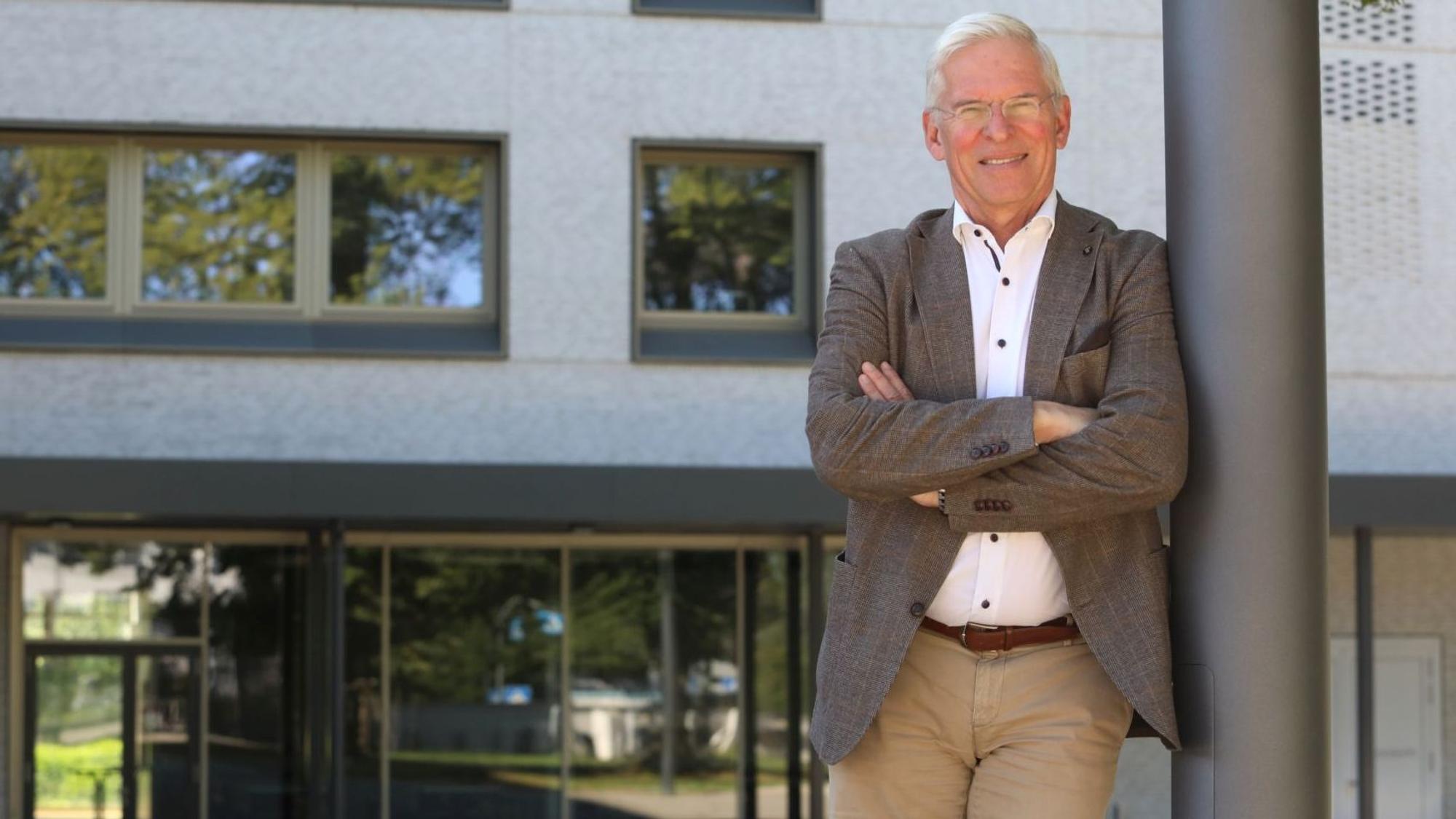 Ein Mann steht, an einen Mast gelehnt, vor der Bad Honnefer Schule.