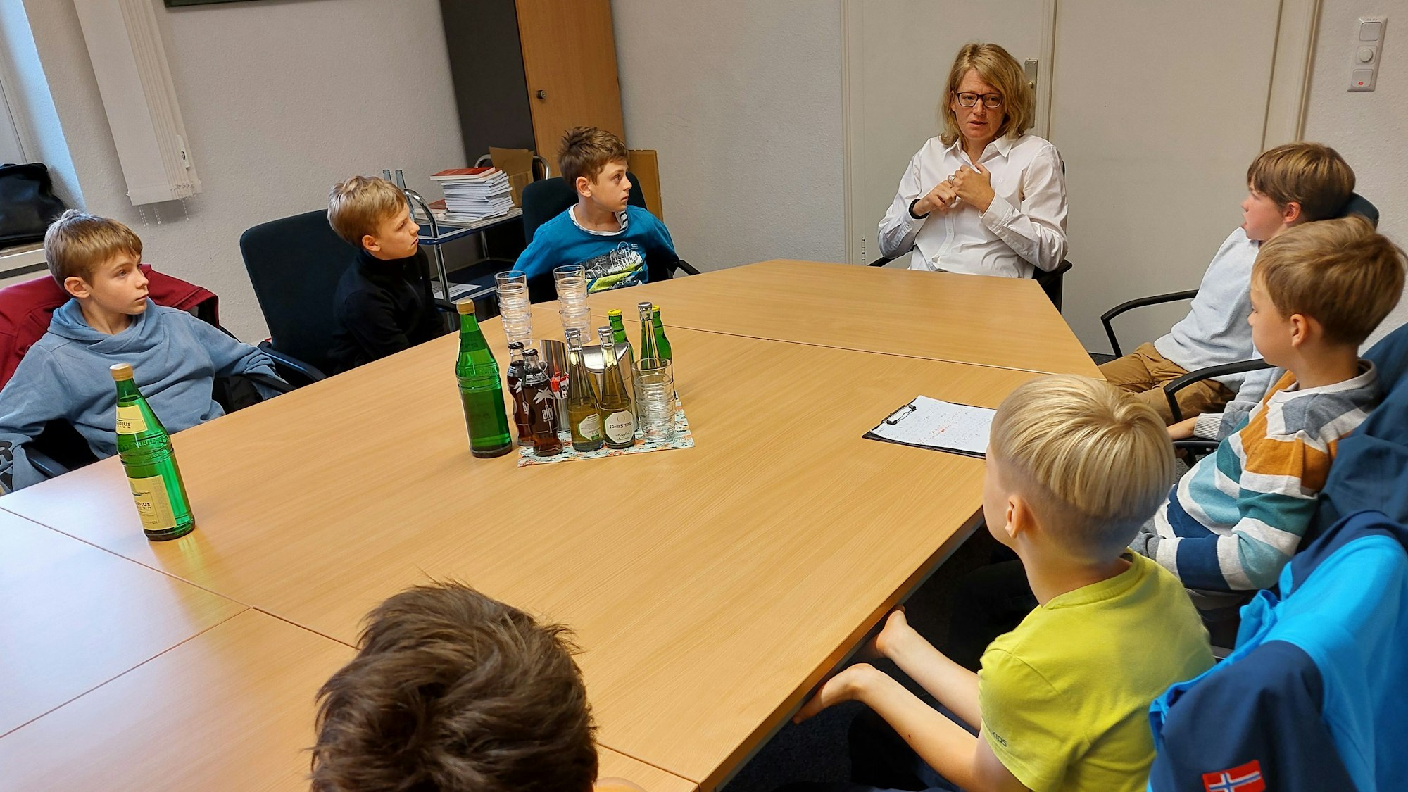 An einem großen Tisch sitzen mehrere Grundschulkinder mit der Bürgermeisterin Alexandra Gauß.