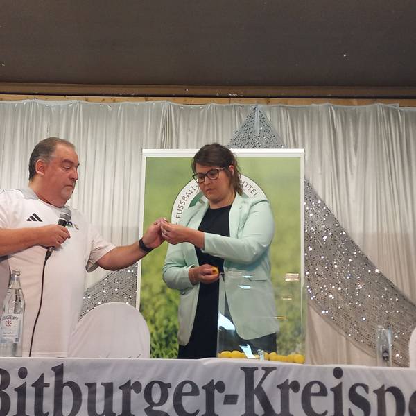 Eine Frau und ein Mann ziehen Lose aus einer Box