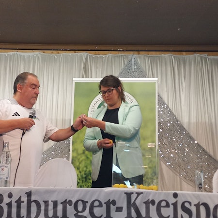 Eine Frau und ein Mann ziehen Lose aus einer Box