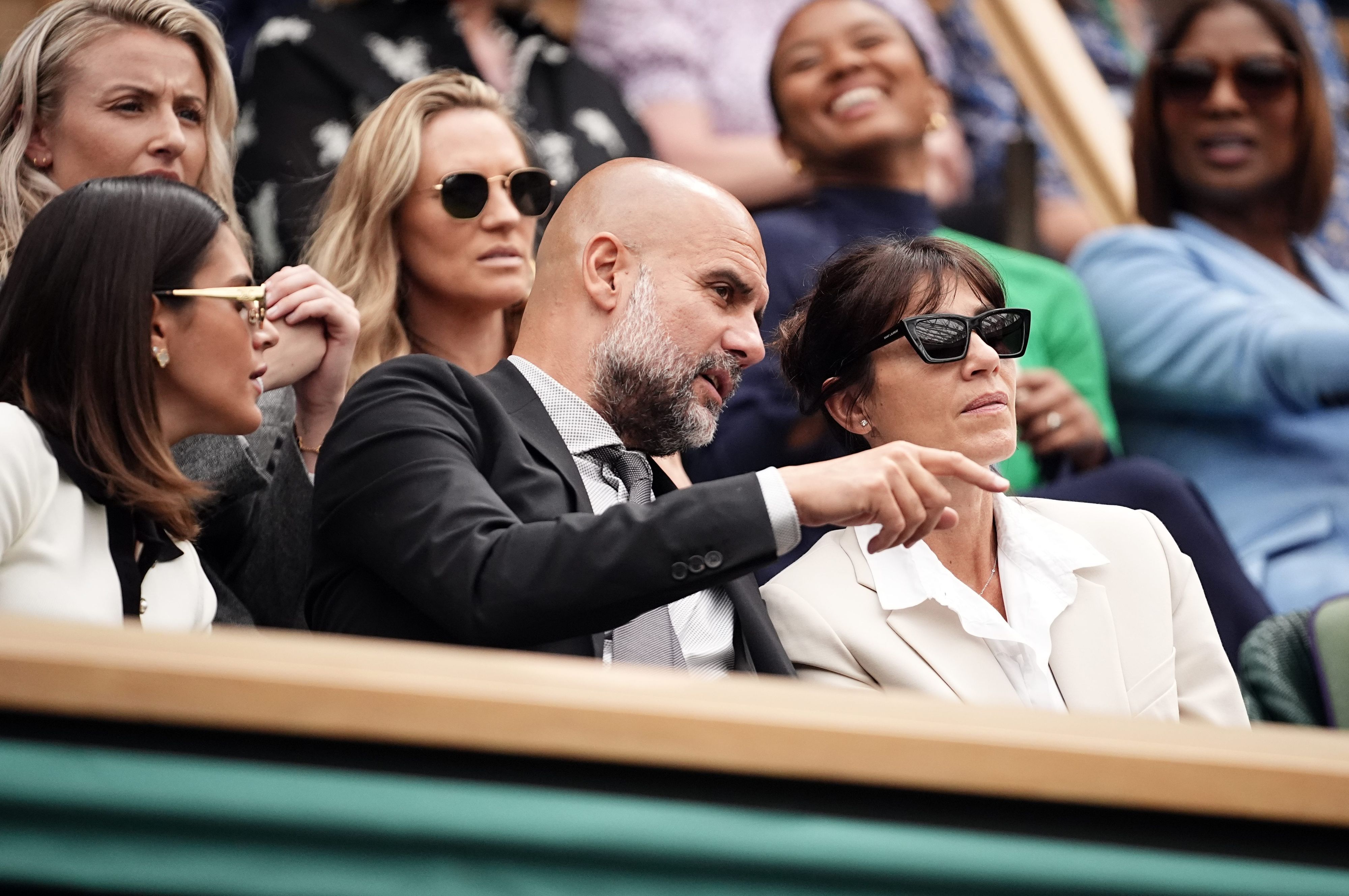 Pep Guardiola sitzt mit seiner Frau Cristina (r) und seiner Tochter Maria (l) am sechsten Tag des Wimbledon-Turniers unter den Zuschauern.