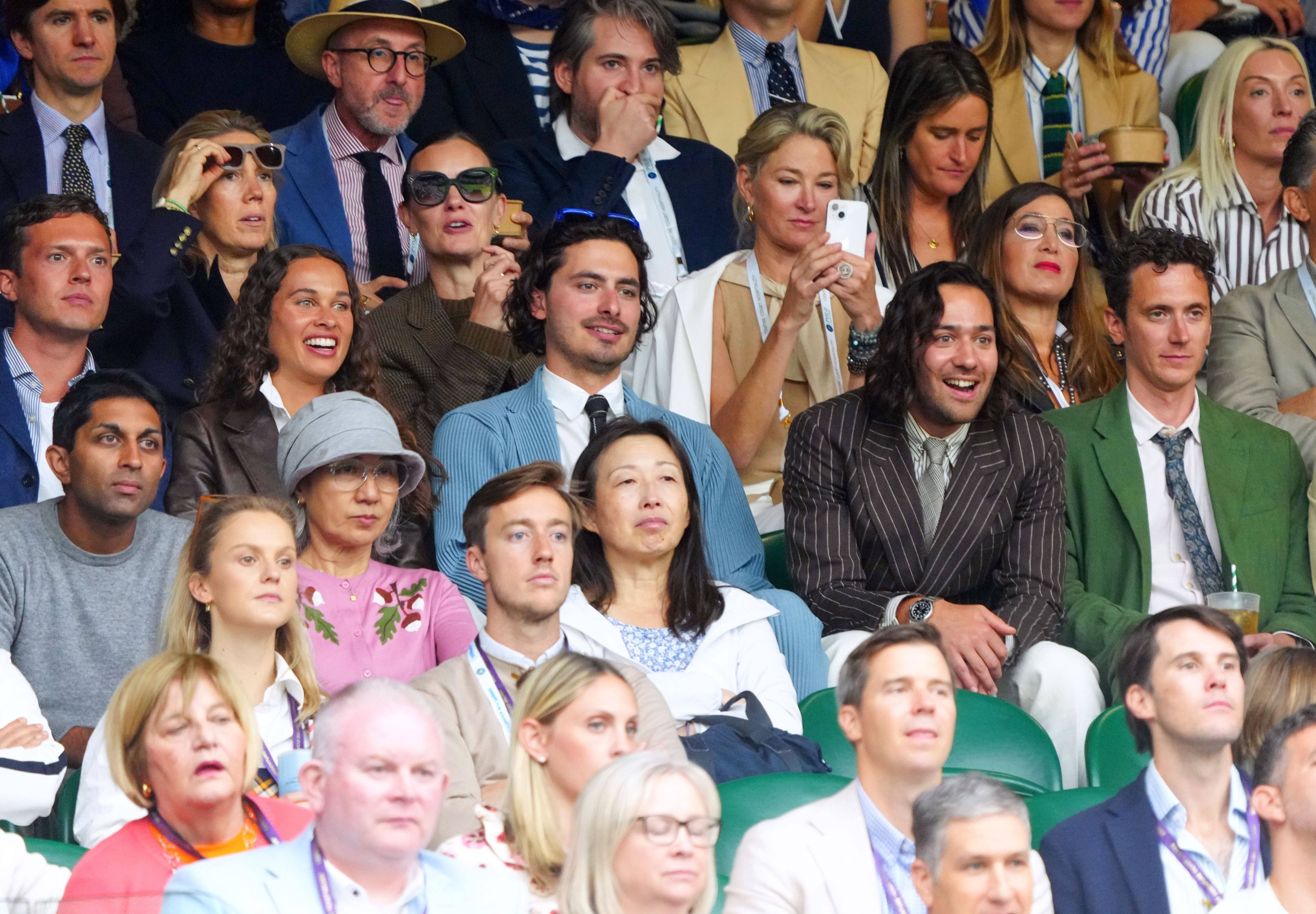 Im braunen Nadelstreifenanzug und bester Laune: Schauspieler Maxim Baldry verfolgt die Geschicke der Tennis-Profis auf dem Centre Court von Wimpledon.