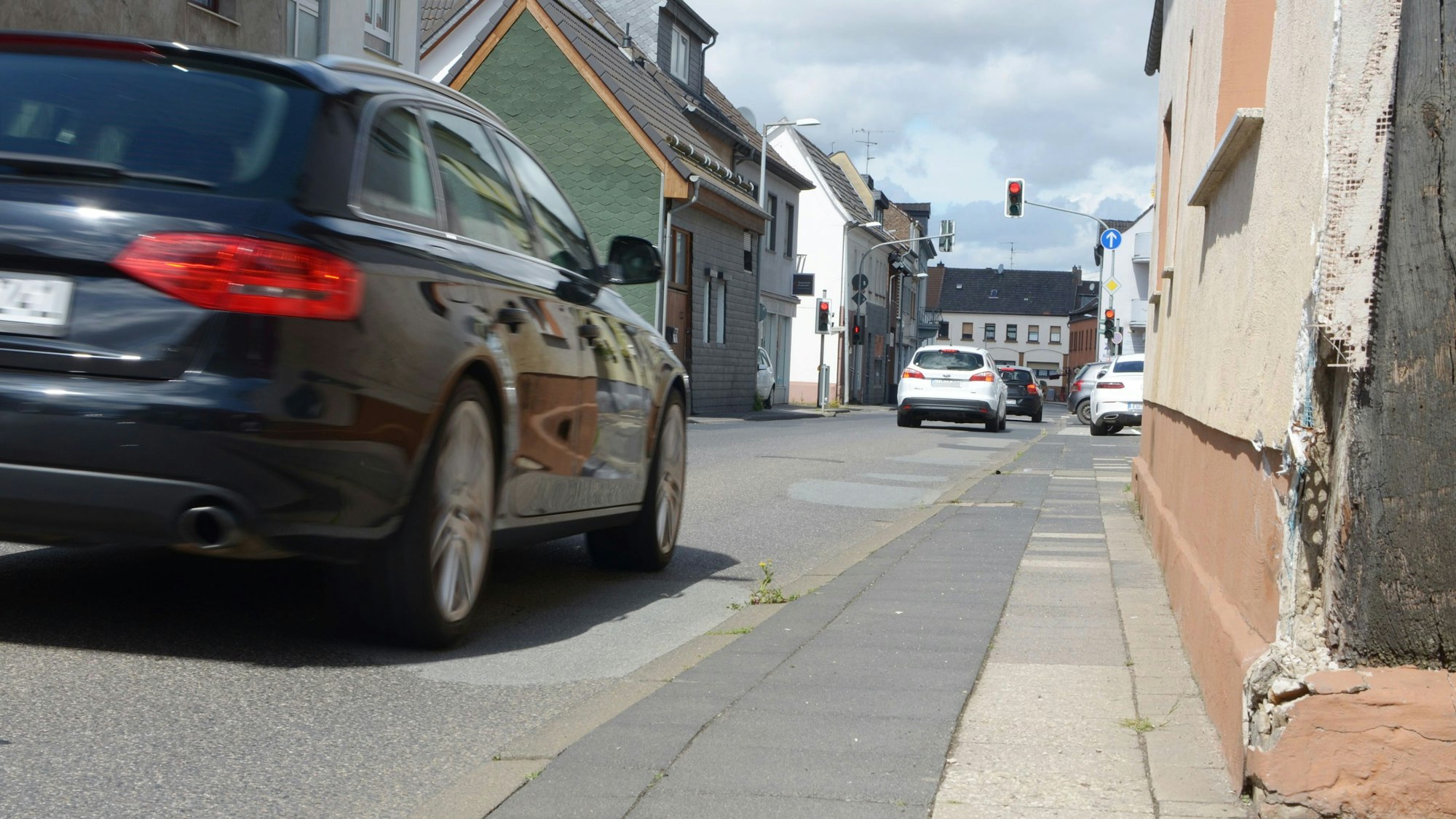 Die Ortsdurchfahrt in Euskirchen-Kuchenheim wird von mehreren Autos in Blickrichtung der Kamera befahren.