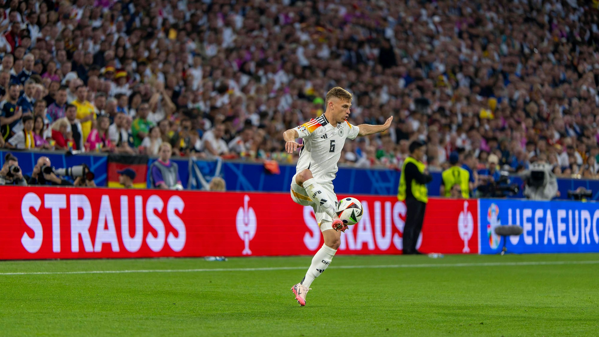 Josua Kimmich vor einem Werbebanner von Strauss