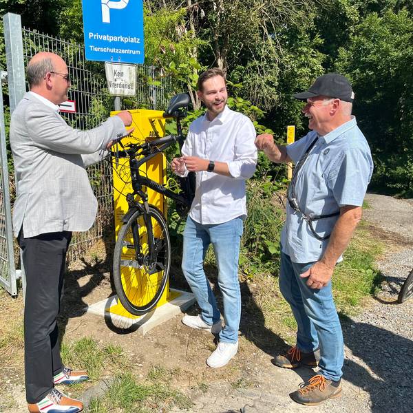Drei Männer an einer Fahrrad-Reparatursäule