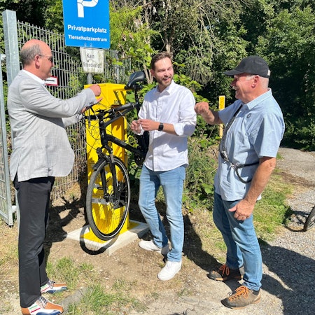 Drei Männer an einer Fahrrad-Reparatursäule