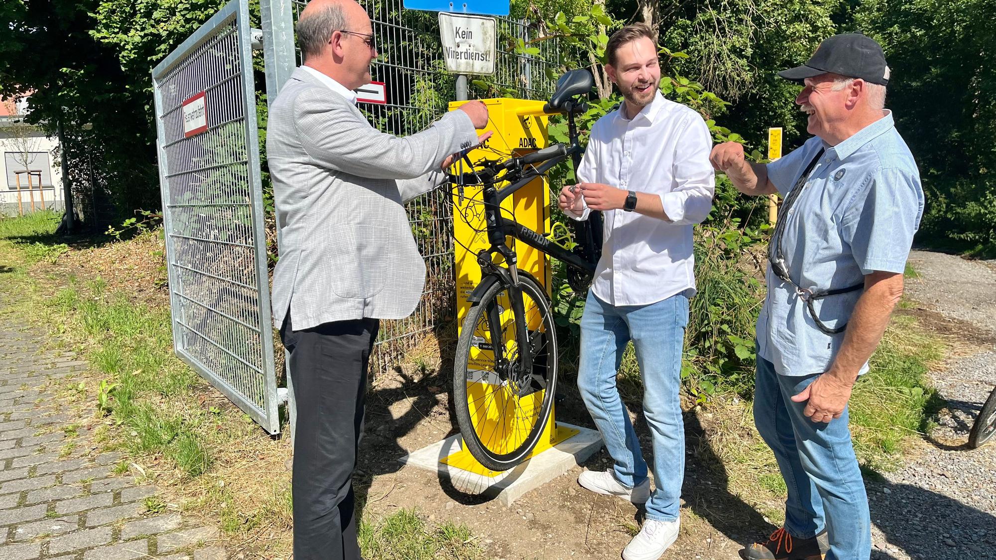 Drei Männer an einer Fahrrad-Reparatursäule