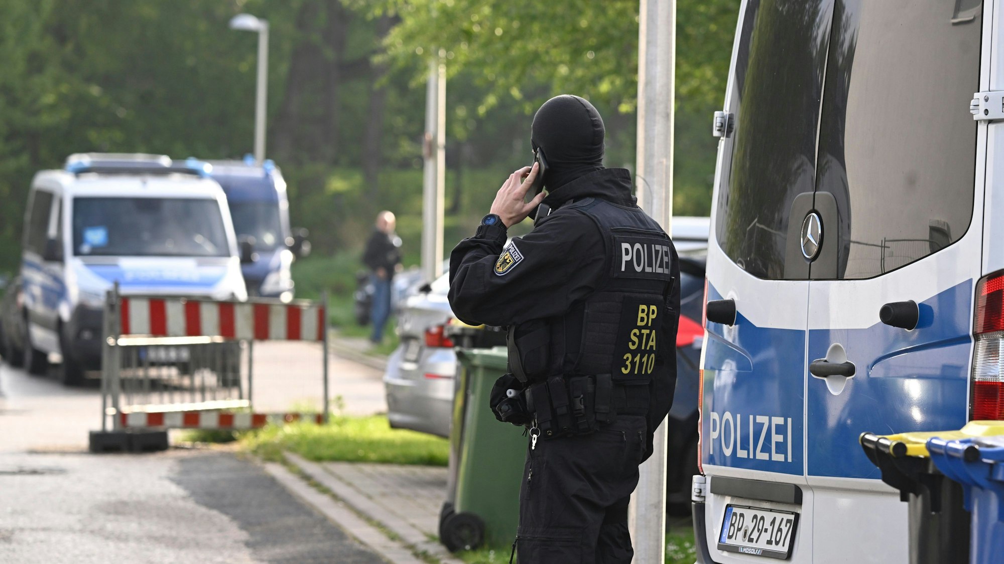 April 2024: Polizisten durchsuchen Wohnungen und Häuser bei der ersten Razzia gegen die mutmaßliche Schleuserbande.