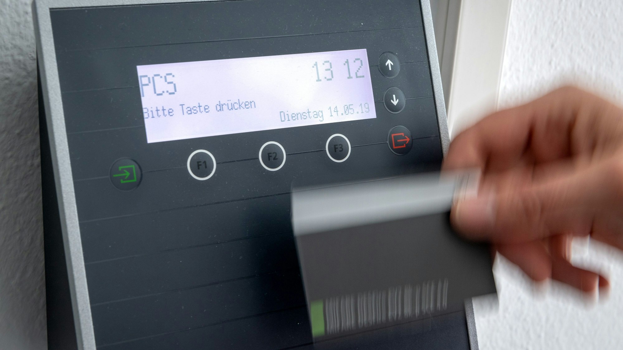 Ein Mitarbeiter erfasst seine Arbeitszeit digital an einem Terminal.