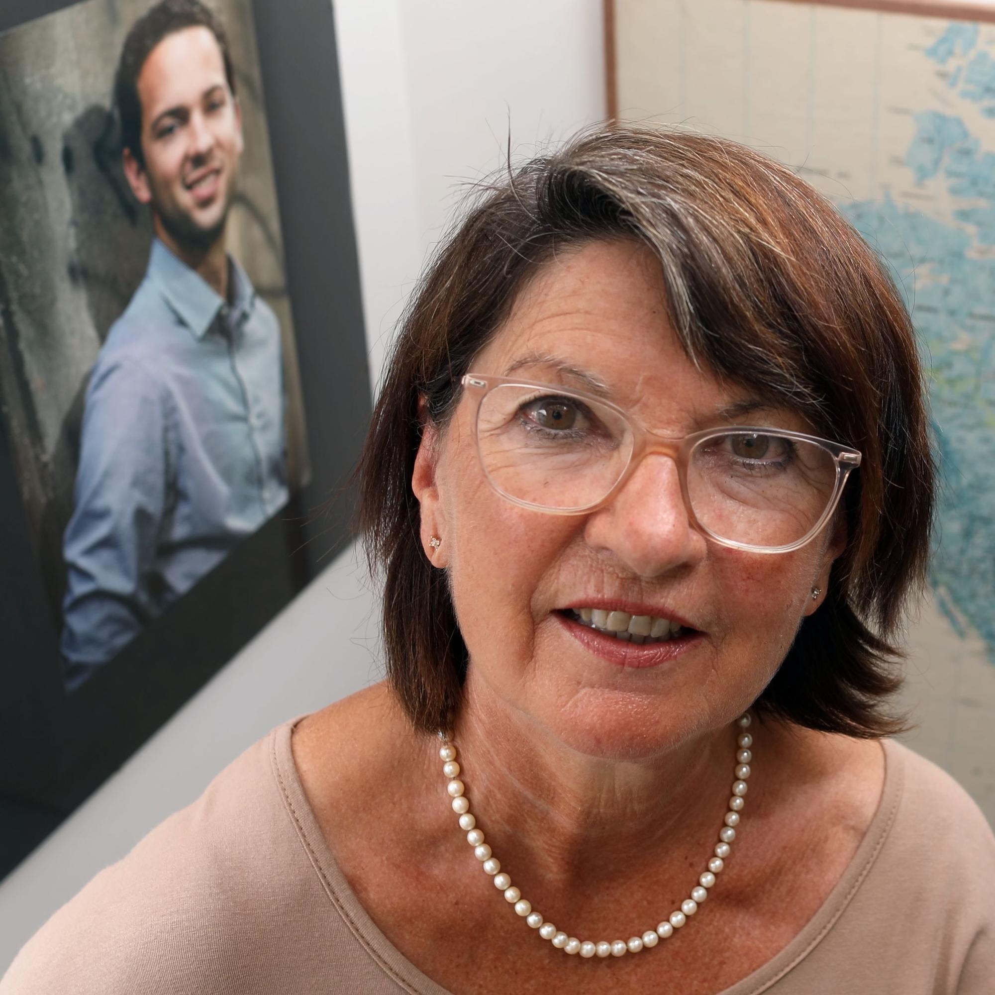 Porträt von Bernadette Rüggeberg, im Hintergrund ein Foto ihres Sohnes