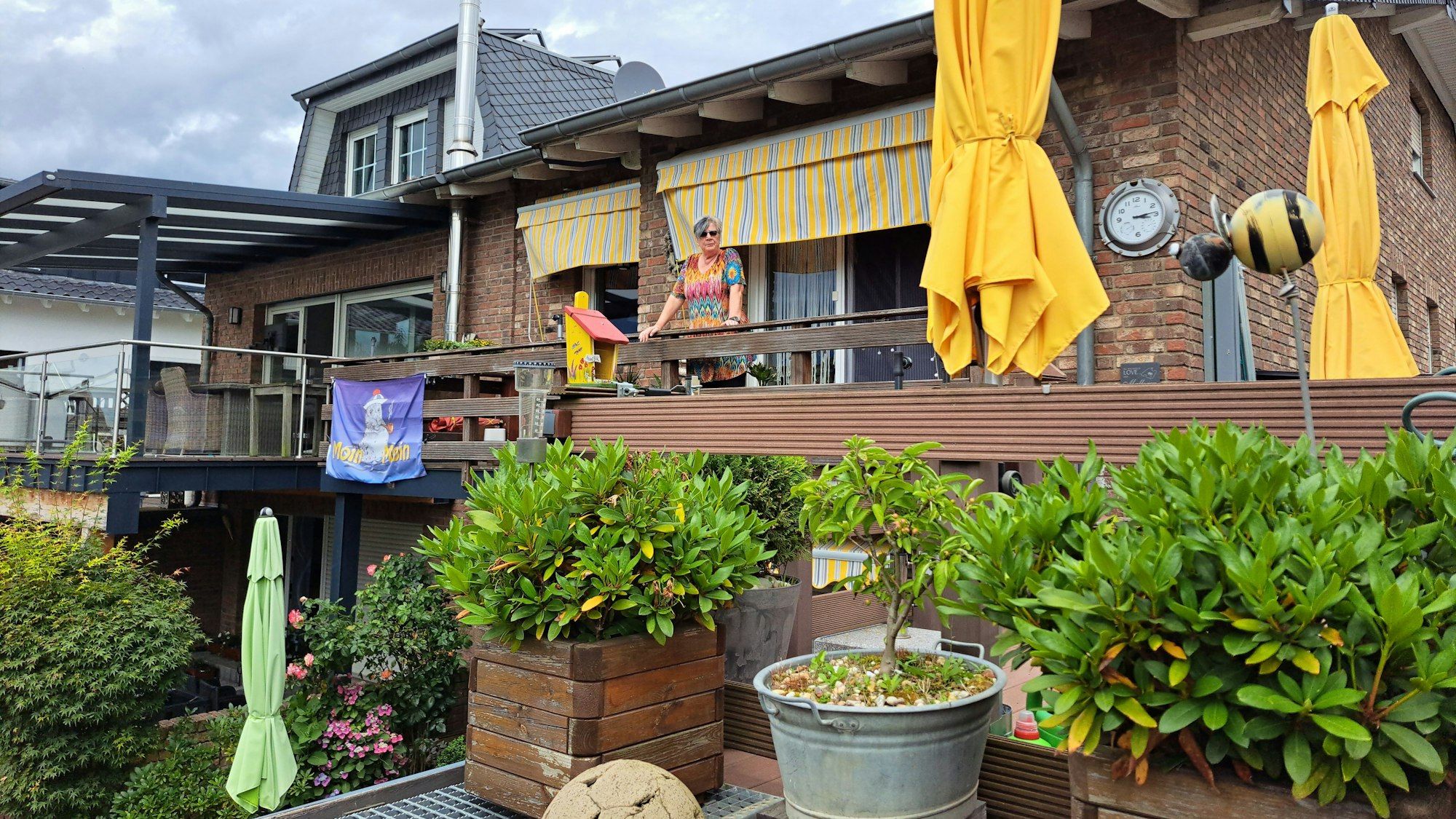 Von ihrem Balkon aus schaut Anne Bär in Richtung Erft. Am Geländer hing nach der Flut das Banner, mit dem gegen die weitere Nutzung der Kiesgrube protestiert wurde.