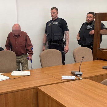 Der Angeklagte mit Verteidigerin Karin Bölter und zwei Wachtmeistern beim Prozessauftakt im Kölner Landgericht