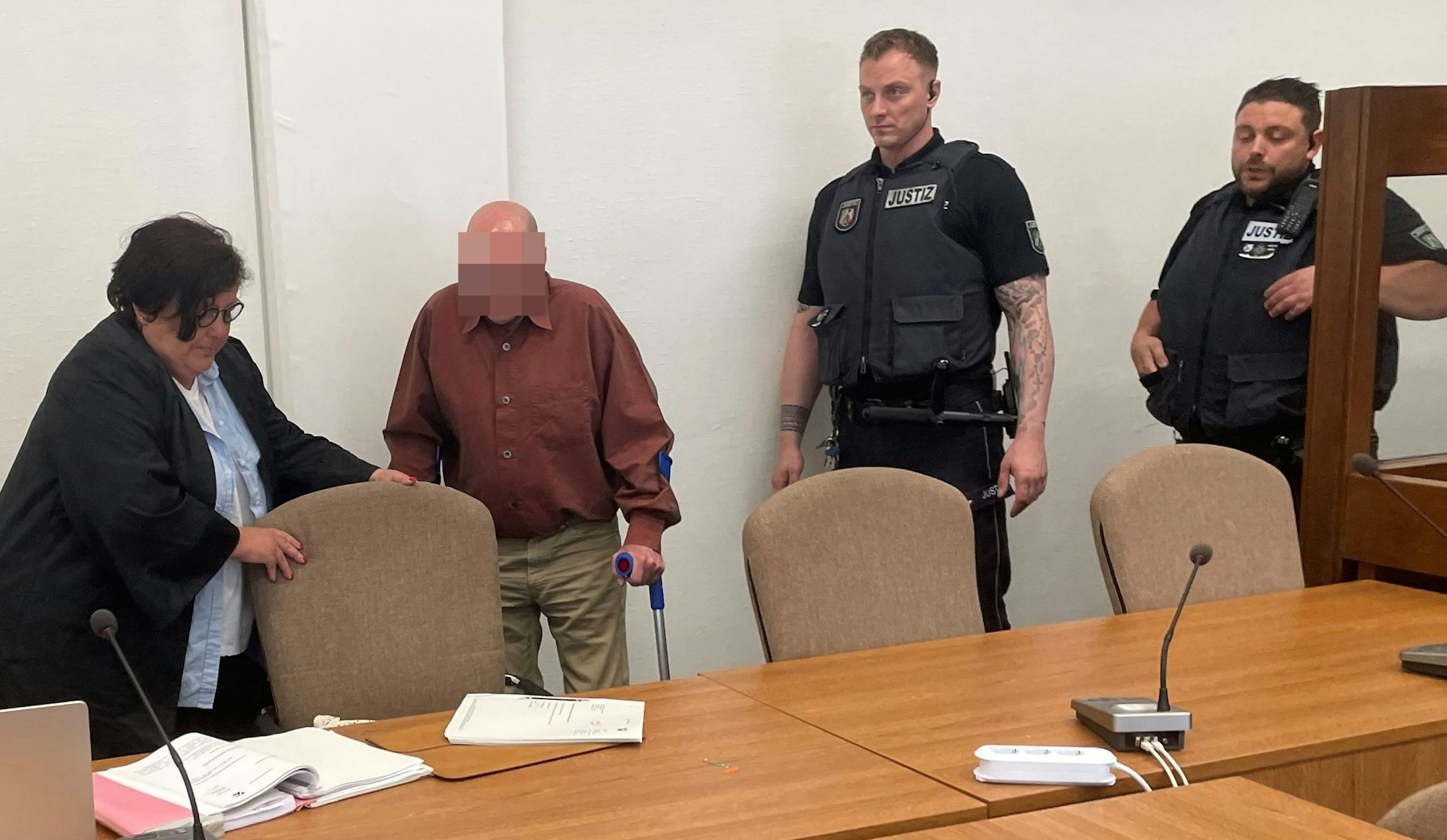 Der Angeklagte mit Verteidigerin Karin Bölter und zwei Wachtmeistern beim Prozessauftakt im Kölner Landgericht.