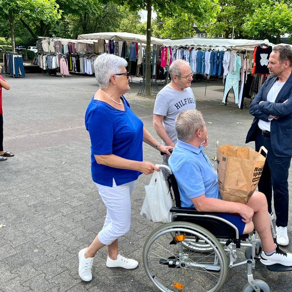 Drei Passanten sprechen auf dem Königsberger Platz mit Oberbürgermeister Uwe Richrath.