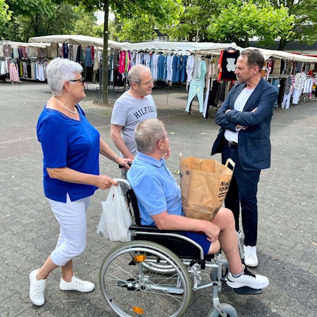 Drei Passanten sprechen auf dem Königsberger Platz mit Oberbürgermeister Uwe Richrath.