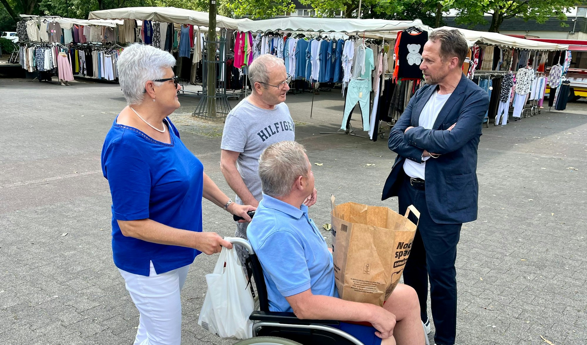Drei Passanten sprechen auf dem Königsberger Platz mit Oberbürgermeister Uwe Richrath.