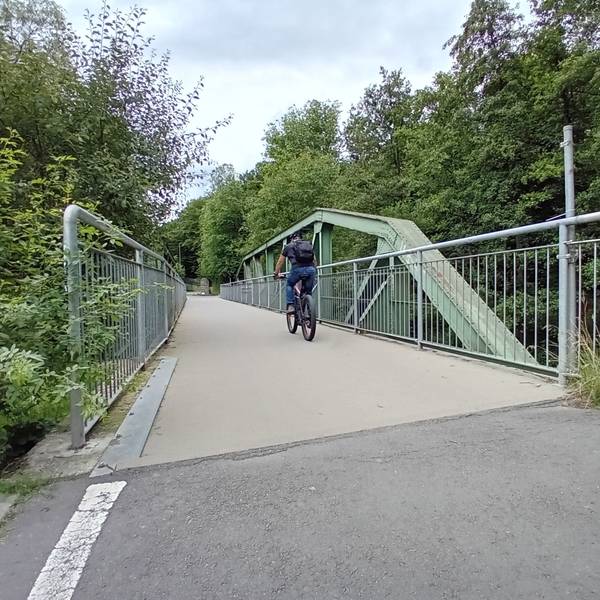 Ein Radfahrer auf einer Brücke.
