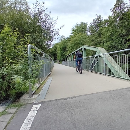 Ein Radfahrer auf einer Brücke.