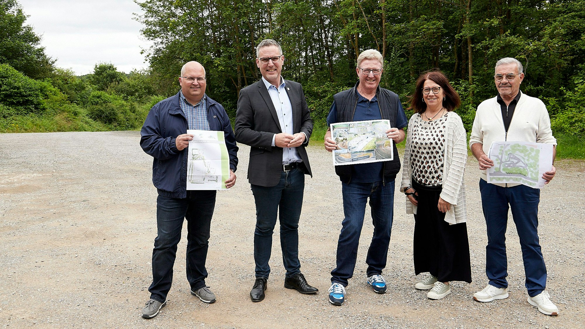 Die fünf Nettersheimer stehen in einer Reihe, drei von ihnen zeigen gedruckte Pläne.