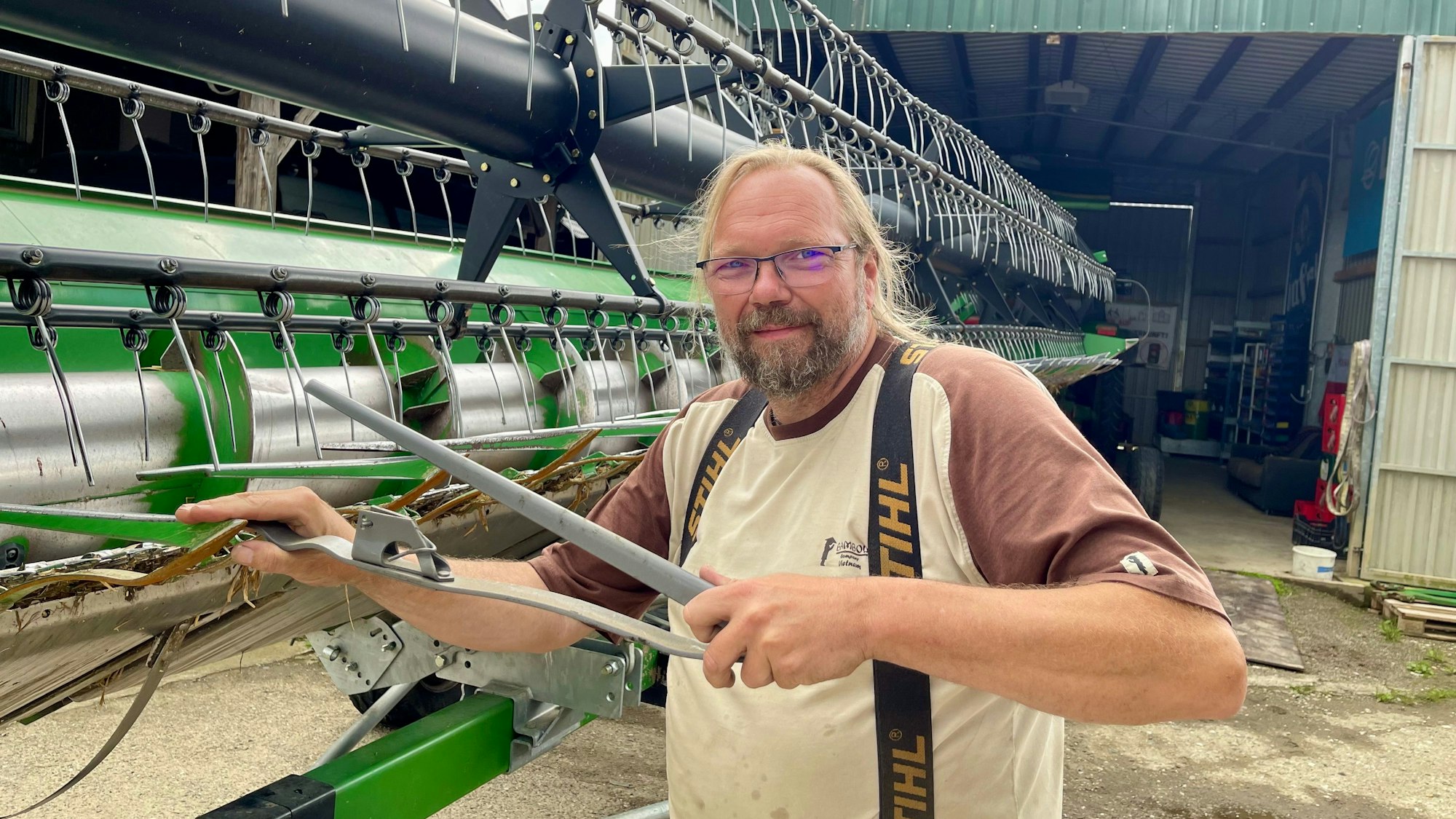 Demeter-Landwirt Bernd Dornbusch aus Hennef-Dambroich bereitet das 9,15 lange Mähwerk für die kommende Ernte vor.