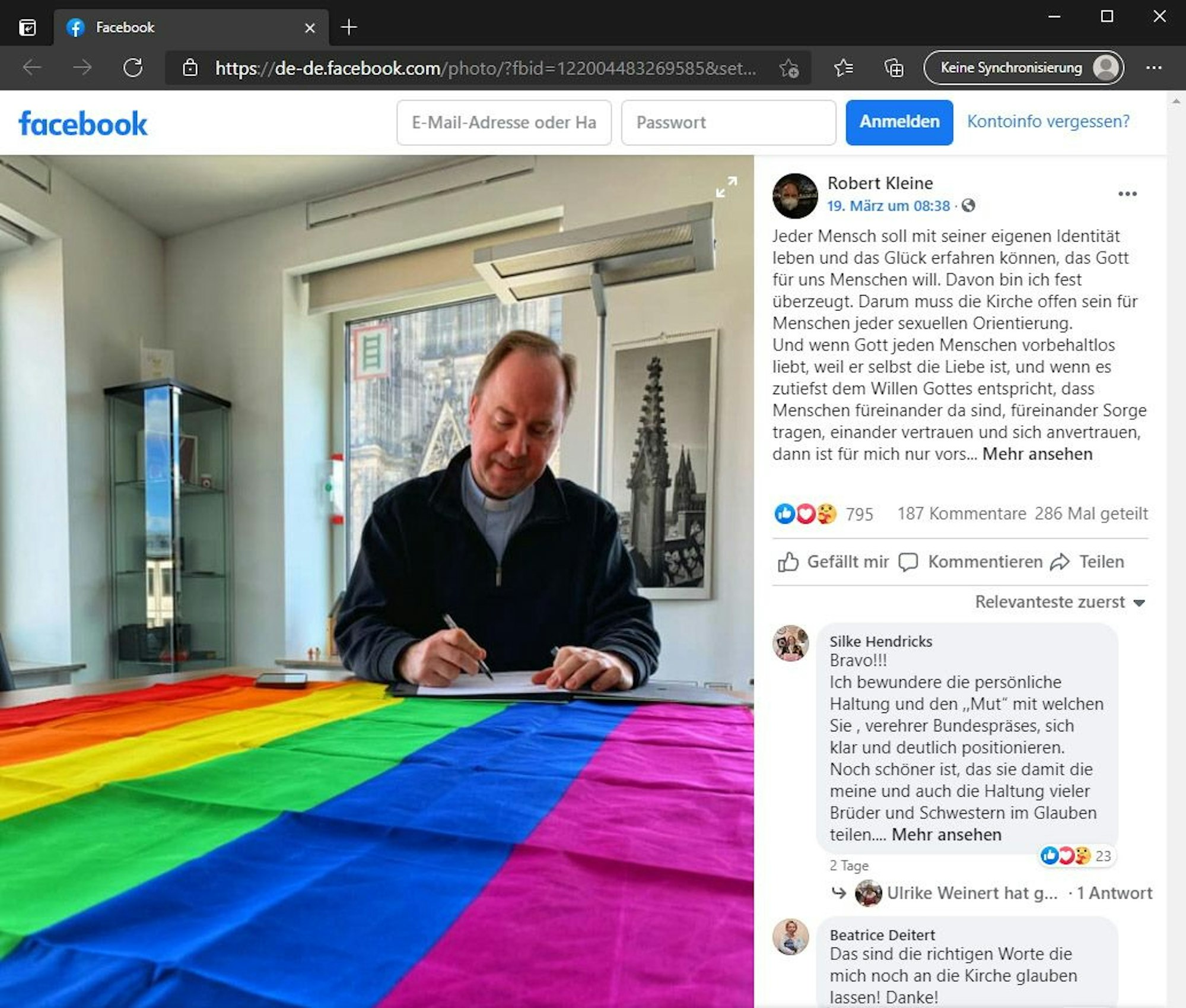 Der Screenshot von Facebook zeigt den Kölner Stadtdechanten Robert Kleine an einem Tisch mit der Regenbogenflagge. Kleine, der auch Domdechant ist, hatte das Foto am 19.03.2021 auf seiner Facebookseite gepostet. Foto: Screenshot Facebook (https://de-de.facebook.com/DomStadtdechantKoeln).