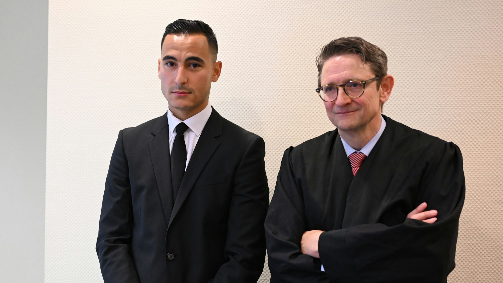Fußballprofi Anwar El Ghazi (l) und sein Anwalt Alexander Bergweiler warten im Sitzungssaal des Arbeitsgerichts auf den Beginn der Verhandlung.