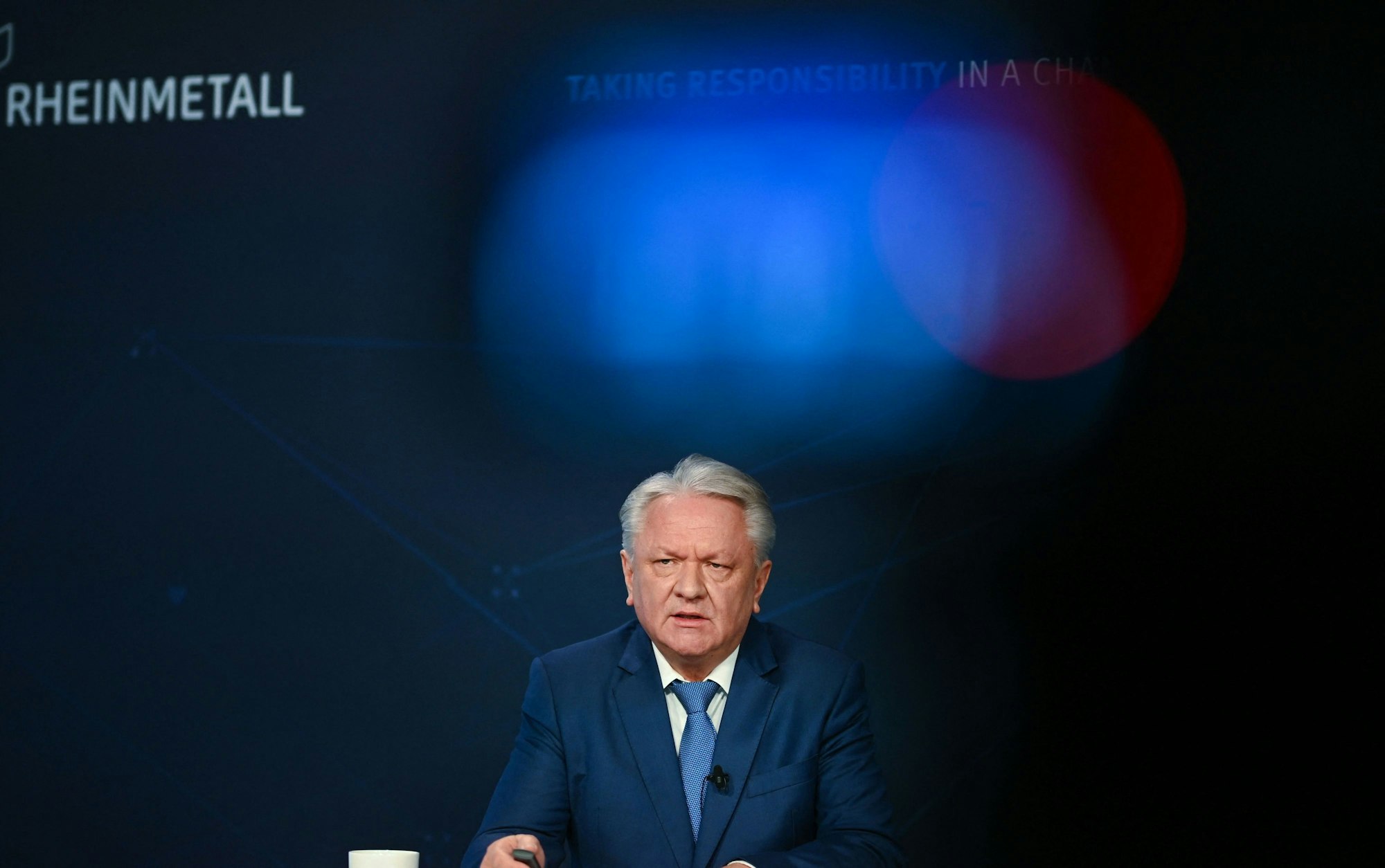 Armin Papperger, Vorstandsvorsitzender der Rheinmetall AG, steht vor einer Wand, auf der „Rheinmetall“ steht.