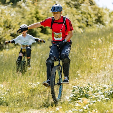 Zu sehen ist ein Einradfahrer bei einem Querfeldein-Rennen.