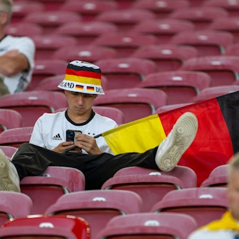 Ein Fan des DFB-Teams schaut nach der Niederlage Deutschlands gegen Spanien im EM-Viertelfinale konsterniert auf sein Smartphone.