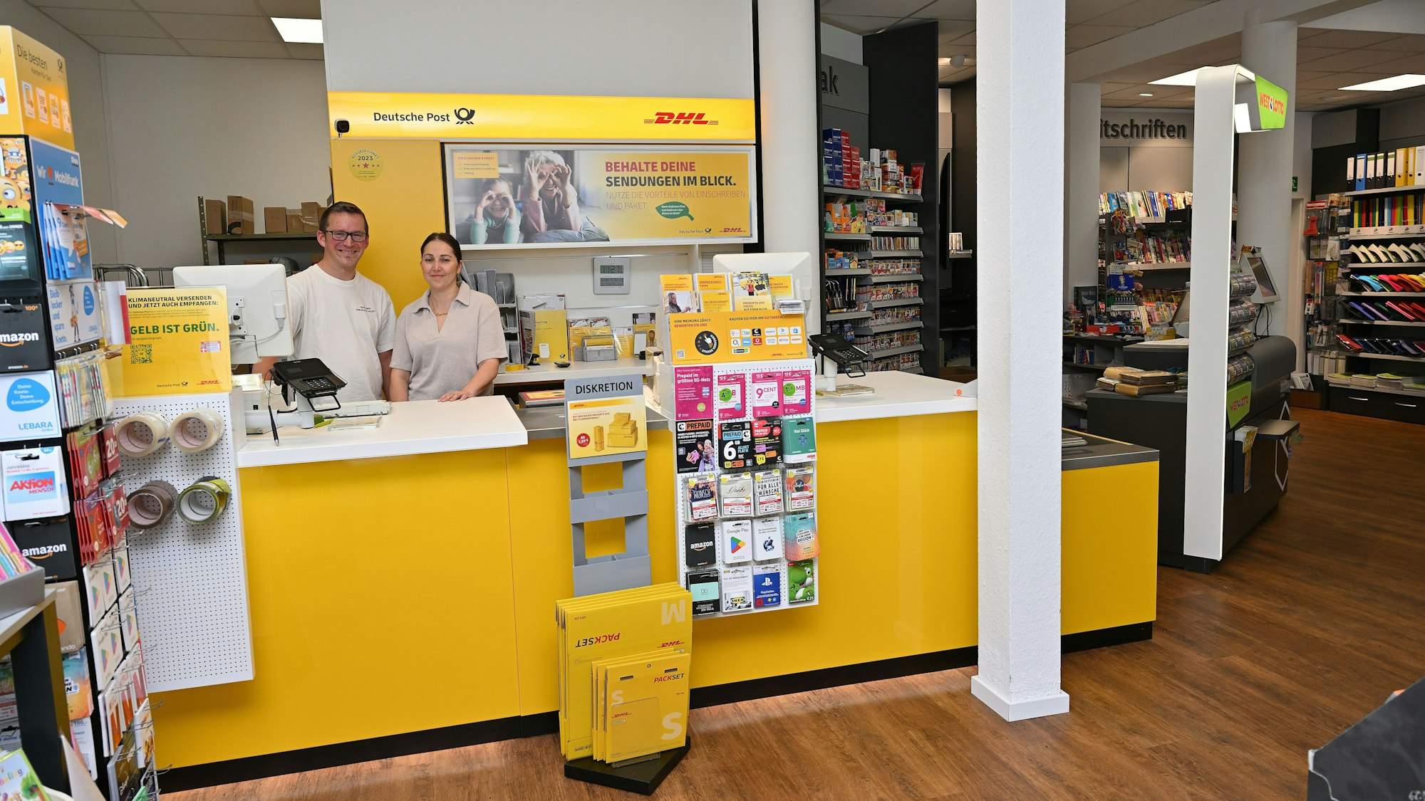 Das Schreibwarengeschäft Polito. Innen ist auch ein gelber Postschalter. Dahinter ein Mann und eine Frau.