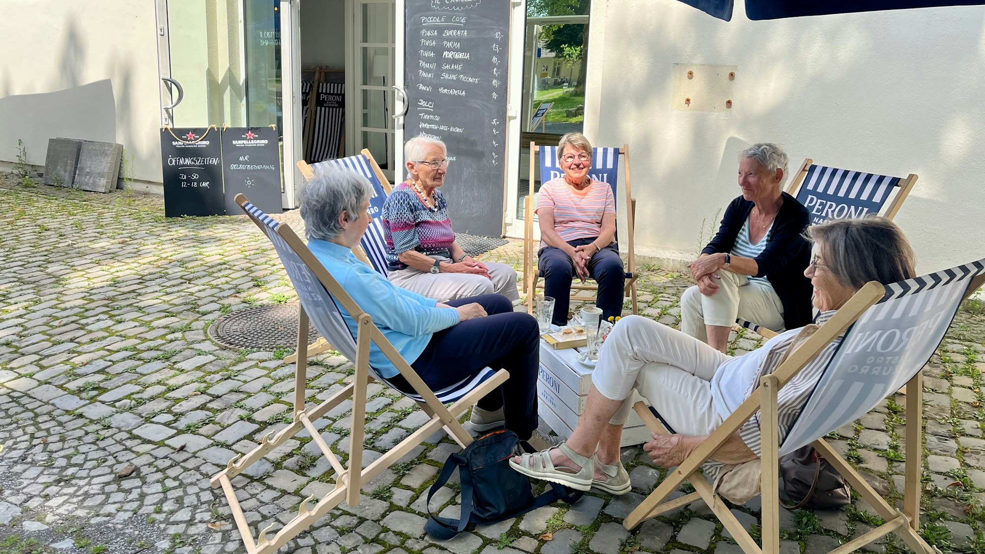Fünf Frauen in Liegestühlen