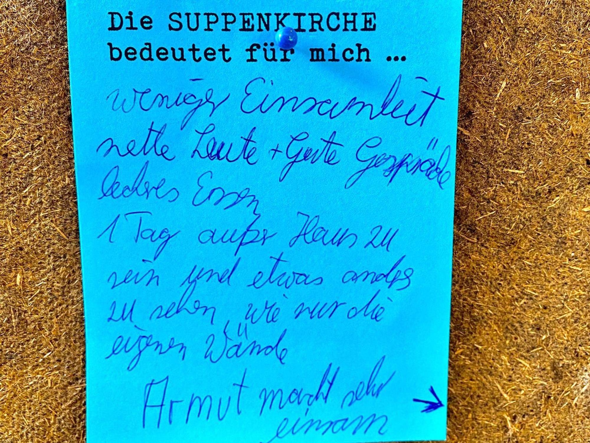 Auf einem blauen Zettel an einer Pinnwand steht, dass Armut sehr einsam macht.