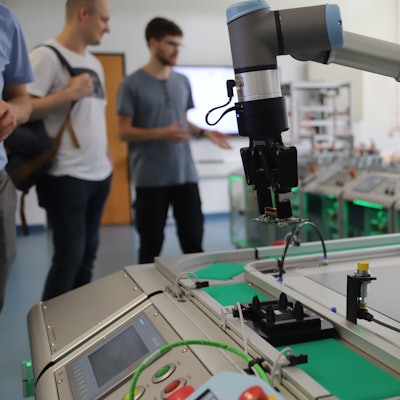 Ein Roboterarm steht am Ende einer vollautomatischen Produktionsstraße.