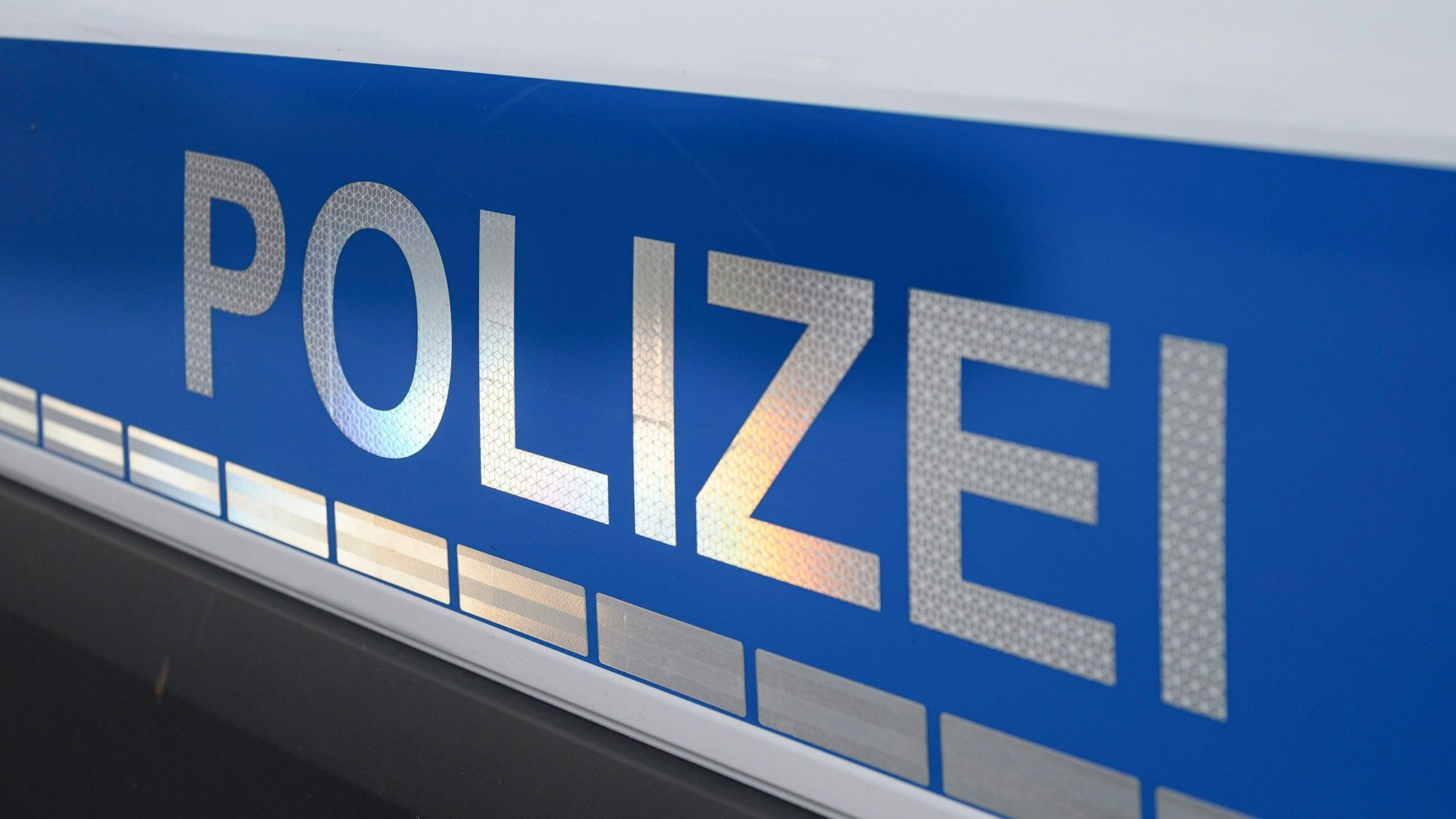 ARCHIV - 22.11.2021, Bayern, Bad Neustadt An Der Saale: Der Polizei-Schriftzug auf einem Einsatzwagen.