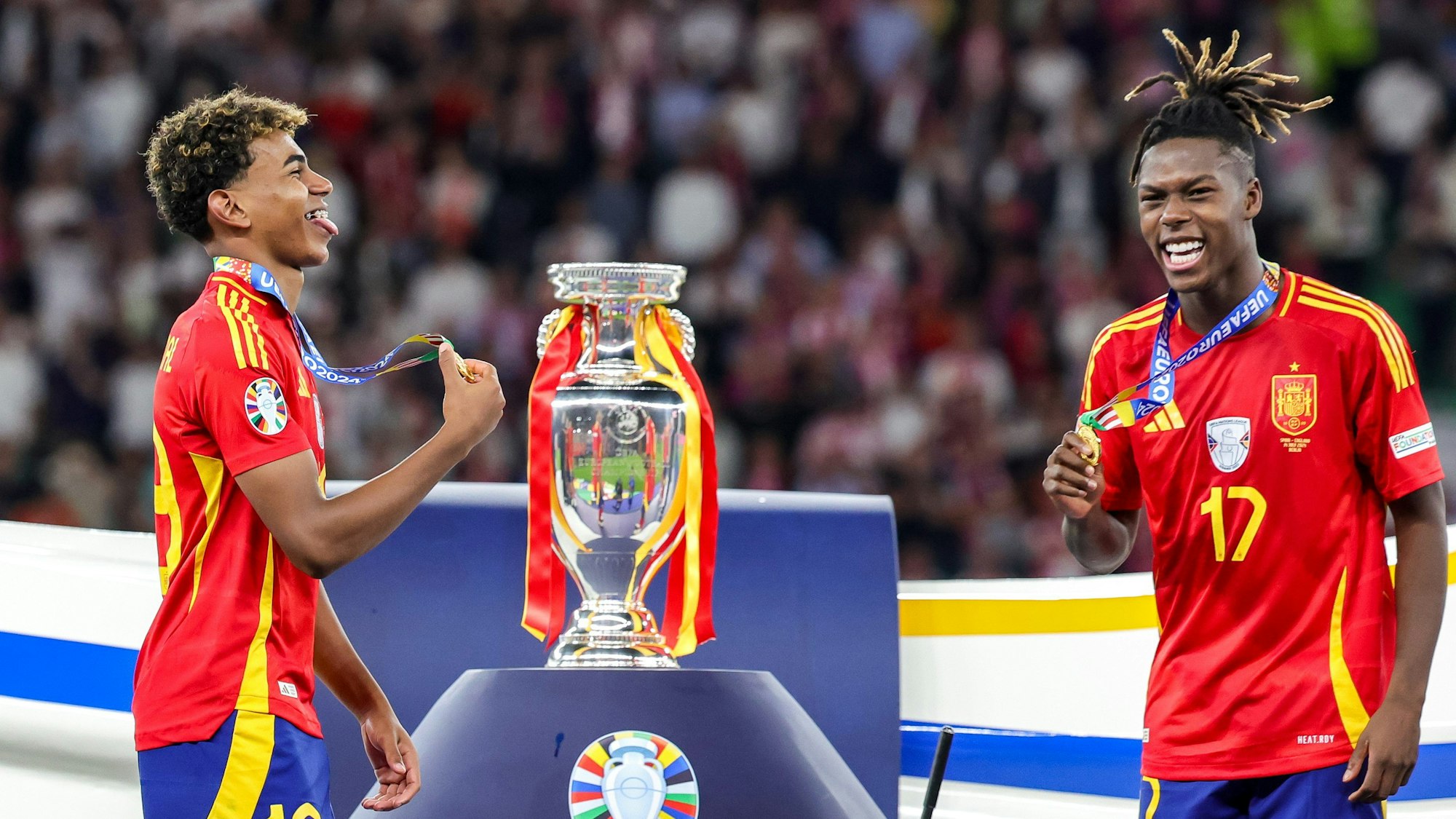 Spaniens Jungstars Lamine Yamal (l.) und Nico Williams jubeln nach dem Sieg vor dem Pokal.