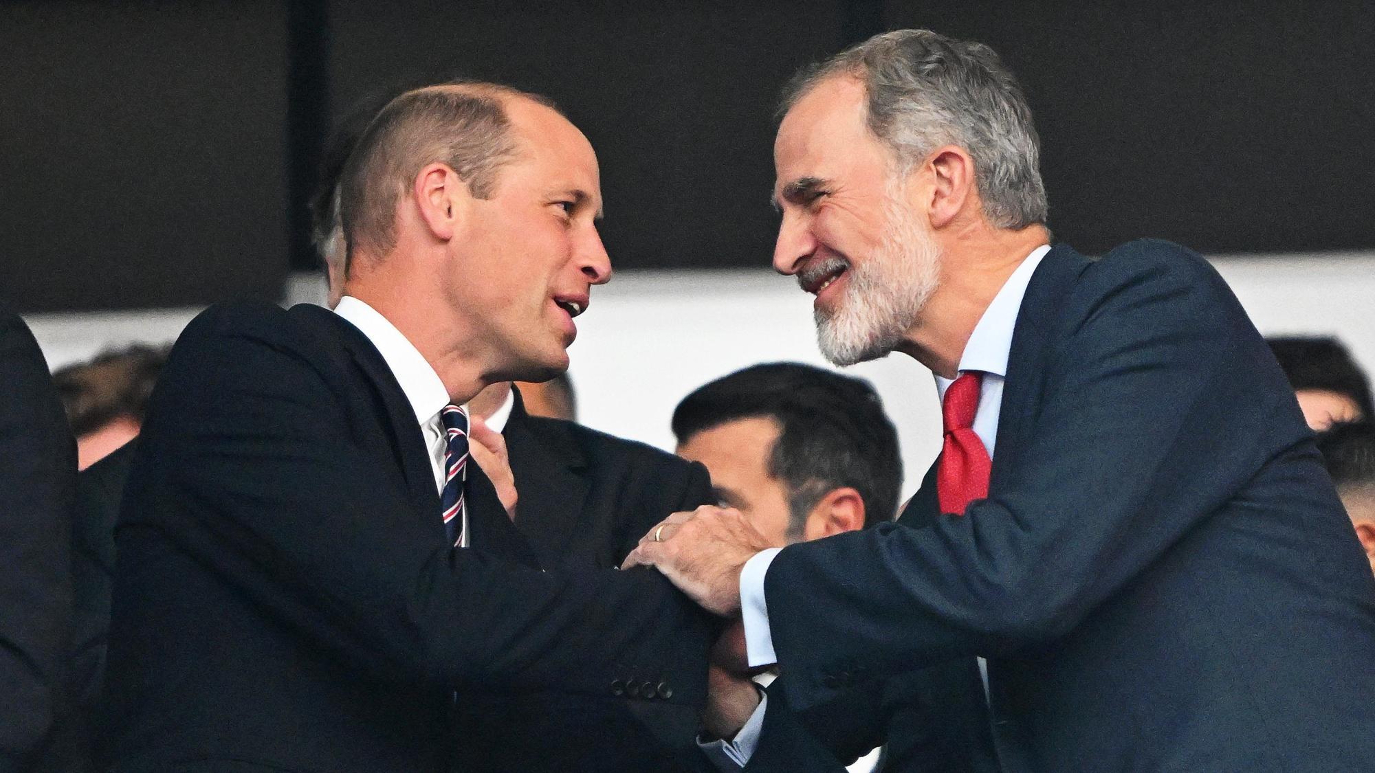 Prinz William (l) und König Felipe VI. begrüßen sich vor Spielbeginn auf der Tribüne.