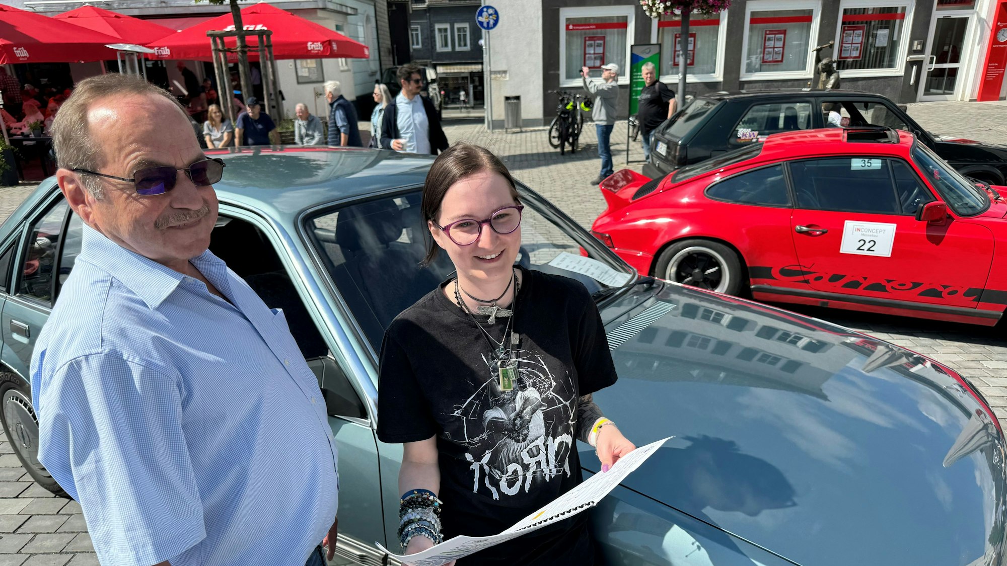 Ein Vater und seine Tochter stehen neben einem Opel Kadett aus den 1980er Jahren.