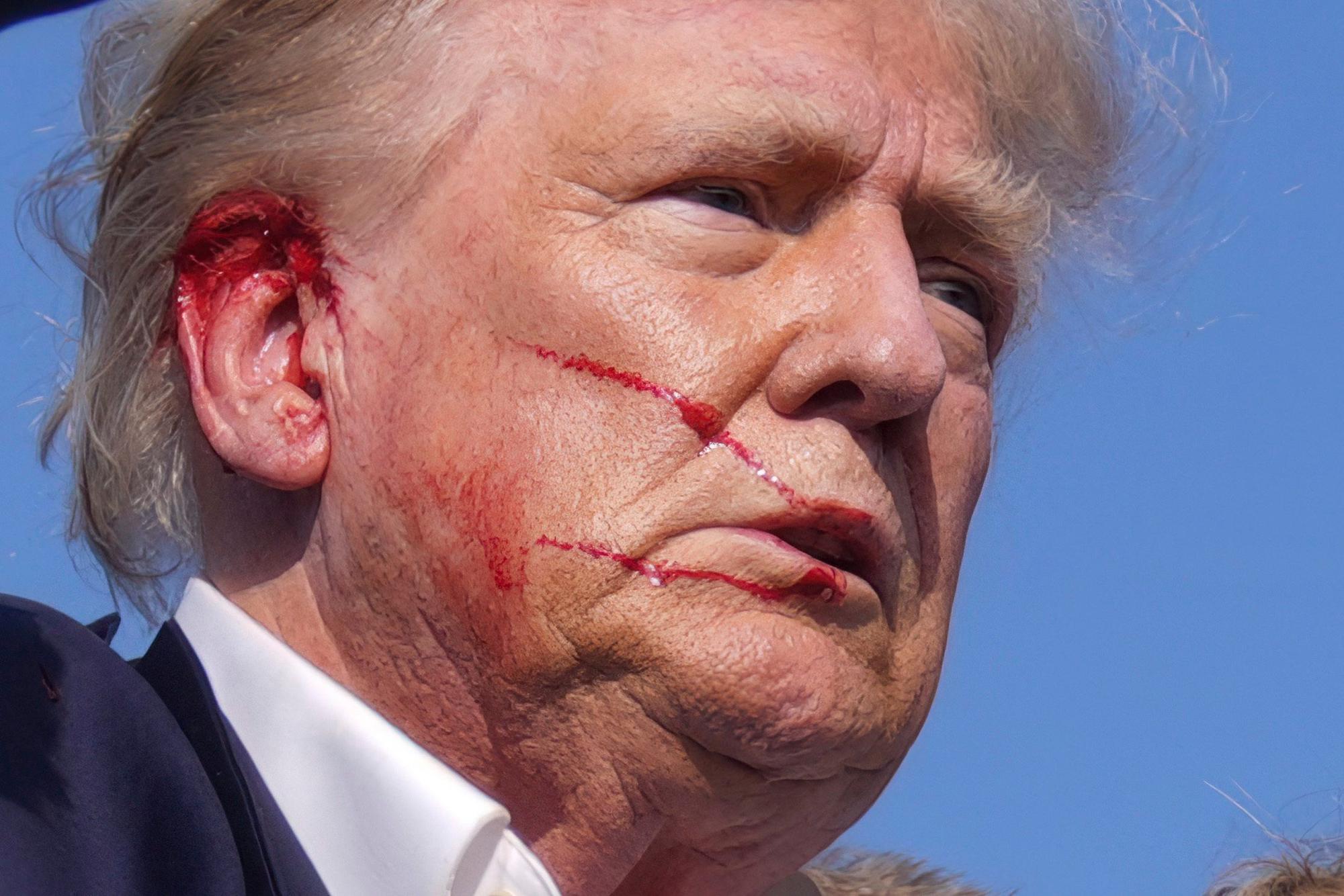 13.07.2024, USA, Butler: Der republikanische Präsidentschaftsbewerber und ehemalige US-Präsident Donald Trump wird bei einer Wahlkampfveranstaltung in Butler, Pennsylvania, von Agenten des US-Geheimdienstes Secret Service von der Bühne gebracht. Trump meldete sich nach der Attacke selbst zu Wort und erklärte, ein Schuss habe ihn am Ohr verletzt. Foto: Evan Vucci/AP/dpa +++ dpa-Bildfunk +++